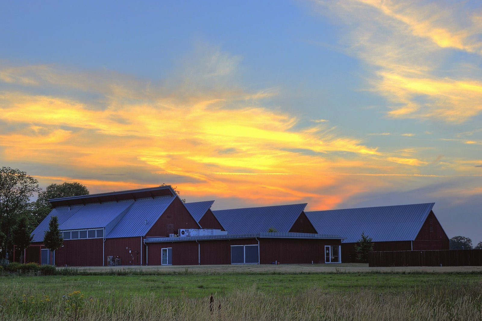 photo of barn near grass field during golden hour