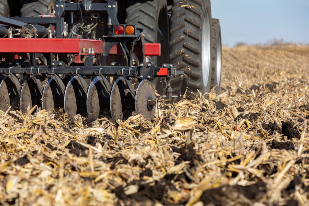 Tractor pulling chisel plow implement in farm field Farm tillage erosion control and soil compaction concept | Pugnalom Credits: JJ Gouin, iStock
