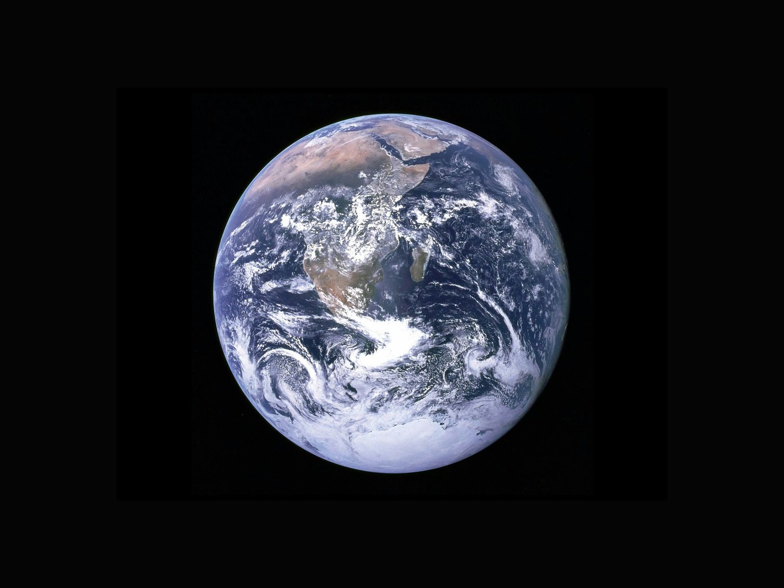 Earth from space, showing Africa and surrounding regions with white cloud cover over the blue oceans.