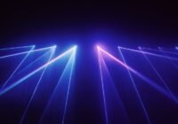 Laser light beams crisscross in blue and pink against a dark background, resembling a laser light show.