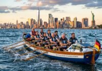 Dragon boat with German Bundestag members paddling on the East River; Manhattan skyline and Statue of Liberty in the background.