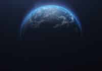 Partial view of Earth from space with a blue glow along the limb and stars in the background, mostly dark.