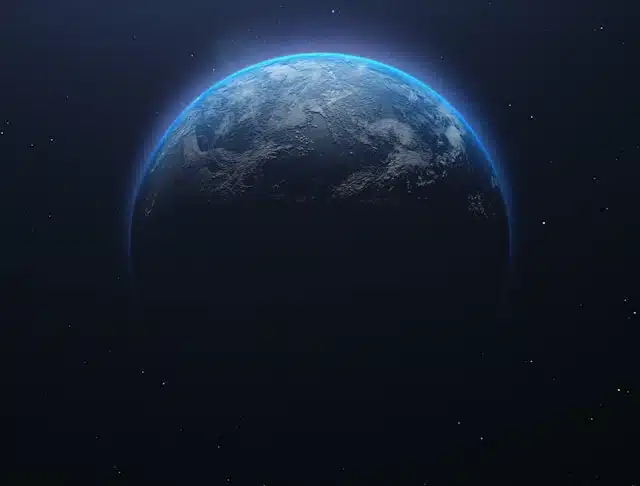 Partial view of Earth from space with a blue glow along the limb and stars in the background, mostly dark.