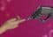 Human hand reaching toward a robotic hand against a magenta tech background, symbolizing collaboration.