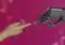 Human hand reaching toward a robotic hand against a magenta tech background, symbolizing collaboration.