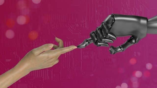 Human hand reaching toward a robotic hand against a magenta tech background, symbolizing collaboration.