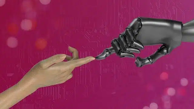 Human hand reaching toward a robotic hand against a magenta tech background, symbolizing collaboration.