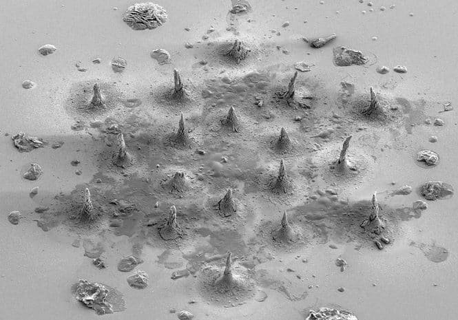 Desert-like surface with many small cone-shaped mounds and scattered rocks across a flat, dusty ground.