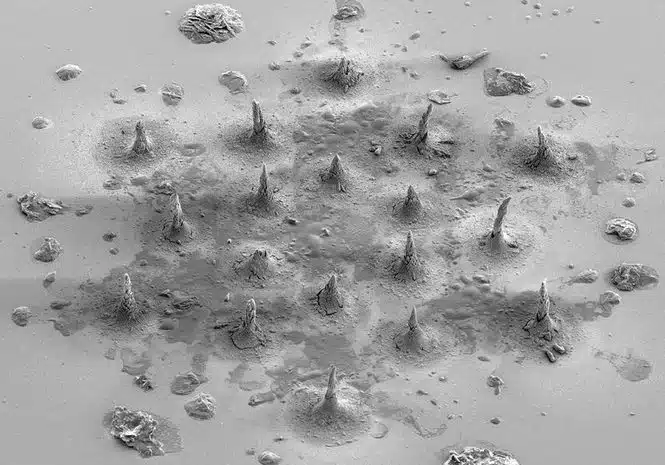 Desert-like surface with many small cone-shaped mounds and scattered rocks across a flat, dusty ground.