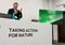 Speaker at a conference podium with a banner reading 'Taking Action for Nature' and a presentation screen beside him.