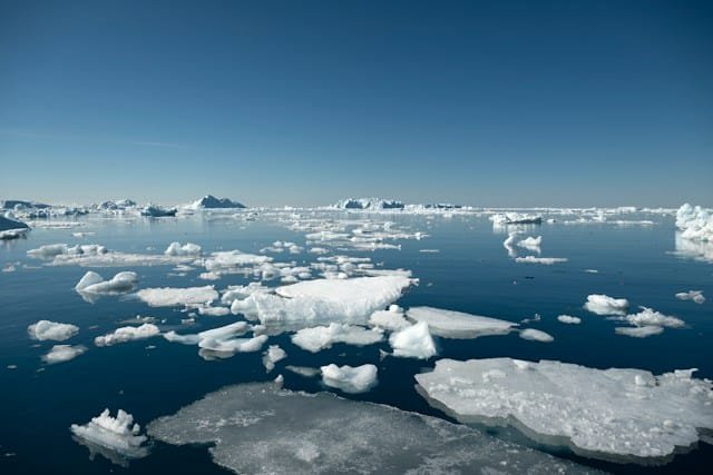 Arctic seascape with scattered ice floes on deep blue water under a clear sky